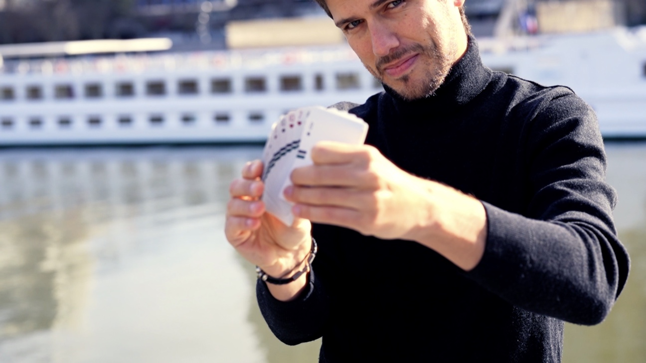 Aurel Magicien manipulant un jeu de cartes au bord de l’eau