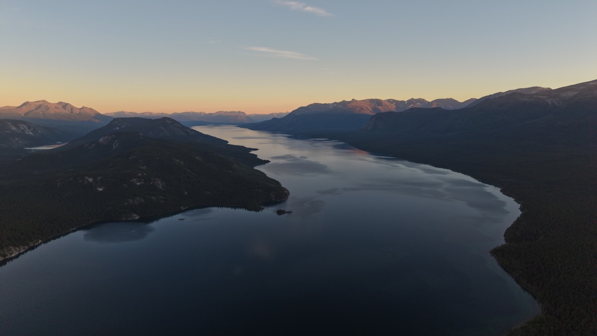 Vue aérienne du lac entre les montagnes éclairées par le soleil couchant