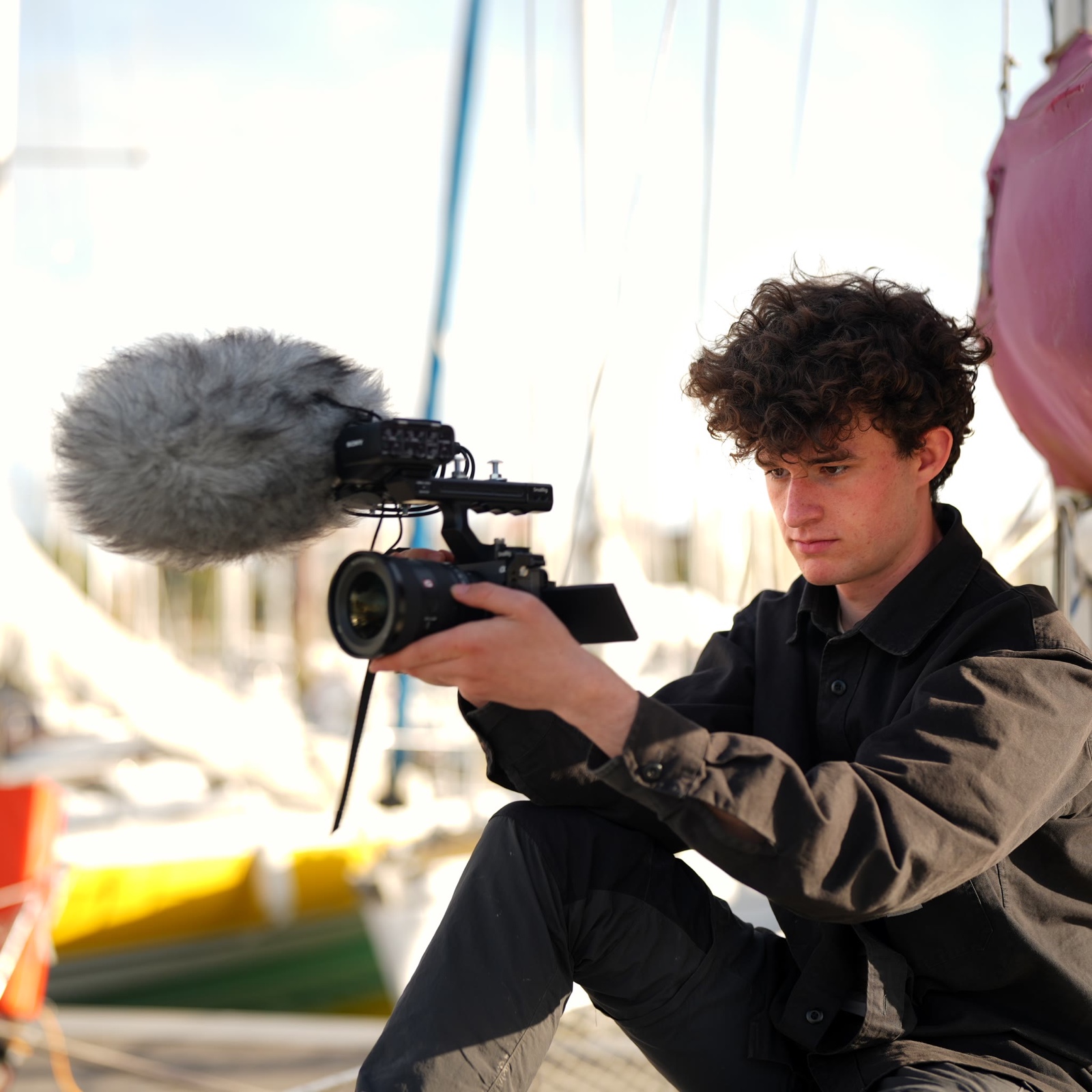 Mathis en tournage avec sa caméra sur un bateau